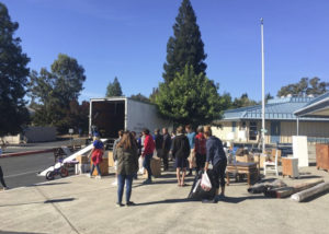 Volunteers and furniture around a moving truck.